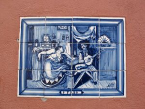 Details of a light blue and white azuleio dedicated to Fado where guitarists and dancers can be seen